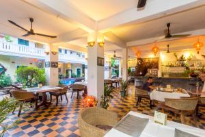 a restaurant with a checkered floor and tables and chairs at Residence Wat Damnak in Siem Reap
