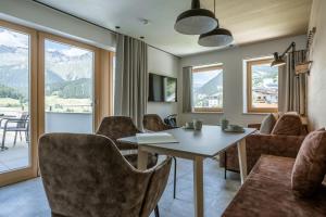 a dining room with a table and chairs and mountains at Arabella Retreat & Spa in Nauders