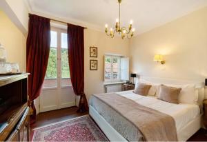 a bedroom with a large bed with red curtains at B&B Principessa di Savoia in Vicoforte