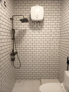 a white tiled bathroom with a shower and a toilet at Faresmaathoda Sunset Stay in Faresmathoda