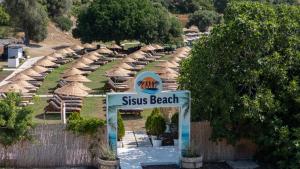 a sign for a beach with straw umbrellas at Sisus Marina Hotel in Çeşme +75 photos