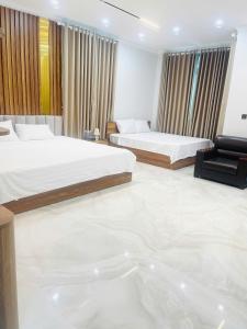 a hotel room with two beds and a couch at Phố Cổ Villa Ninh Bình in Kỳ Vĩ