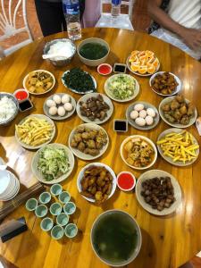 a wooden table with plates of food on it at Ma Pi Leng Horizon Hostel - Tour & Motobike rental in Ha Giang