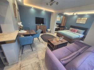 a living room with a purple couch and a table at Miradi Art Apartment in Stara Zagora