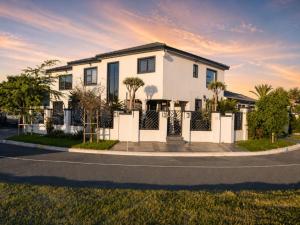 a white house with a fence on a street at Salt and stone in Cape Town