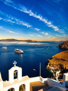 a church with a view of a body of water at Sofi Rooms in Fira