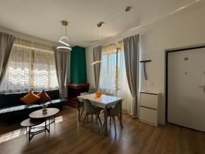 a living room with a table and chairs and a couch at Rome - Green Hills condominio in Colleverde +17 photos