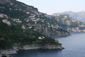 a village on the side of a mountain next to the water at Hotel Belvedere in Conca dei Marini