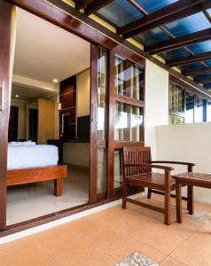 a bedroom with a bed and a table and a bench at Sunset Beach Villas in Haad Rin