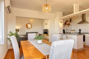 a dining room and living room with a table and chairs at Casa Morendo in Teulada