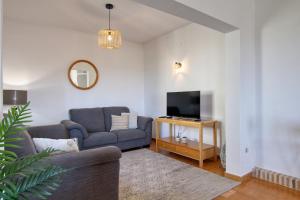 a living room with a couch and a tv at Casa Morendo in Teulada