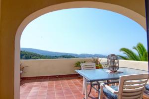 a patio with a table and chairs on a balcony at Casa Morendo in Teulada