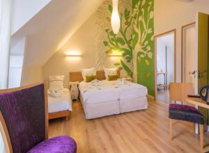a bedroom with two beds and a table and chairs at Au Pré Carré in Plumergat