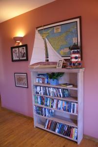 a book shelf filled with books and a sail boat on it at Olive Tree House in Anoyira