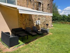 a patio with chairs and a table and an umbrella at Mon Petit Paradis avec Piscine Intérieure Privative Chauffée et climatisation in Lournand