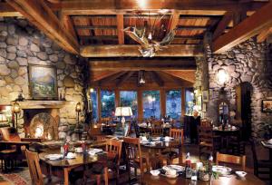 a restaurant with tables and chairs and a stone wall at El Portal Sedona Hotel in Sedona