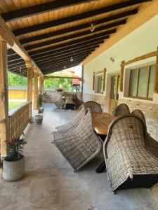 a patio with wicker chairs and a table on a porch at Cuib de Munte in Brezoi