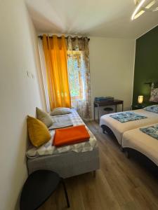 a room with two beds and a chair and a window at Rome - Green Hills condominio in Colleverde