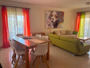 a living room with a green couch and a table at Vilamoura TOP MouraPraia in Vilamoura