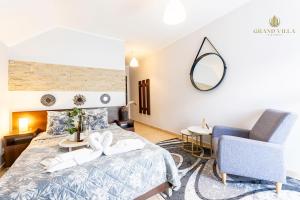 a bedroom with a bed and a chair and a mirror at GRAND VILLA USTKA- POKOJE z BALKONAMI I TARASAMI, PARKING W CENIE ! in Ustka
