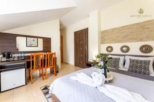 a hotel room with a bed and a desk at GRAND VILLA USTKA- POKOJE z BALKONAMI I TARASAMI, PARKING W CENIE ! in Ustka