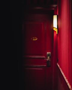 a red door with a gold door knob on it at Madame C - Hôtel Particulier in Strasbourg