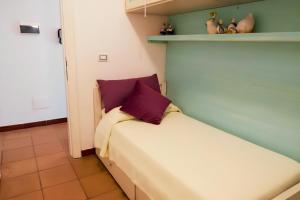 a bedroom with a bed with a purple pillow on it at Appartamento Monte Ladu in Porto Rotondo +7 photos