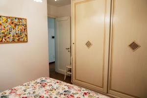 a bedroom with a bed and a door with a painting at Appartamento Monte Ladu in Porto Rotondo