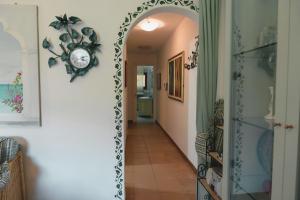 a hallway with an archway with a clock on the wall at Appartamento Monte Ladu in Porto Rotondo