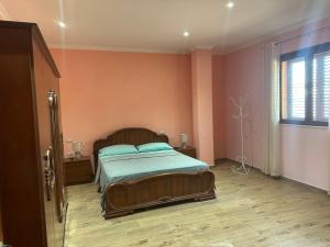 a bedroom with a large bed and a window at Busulla Guest House in Shijak