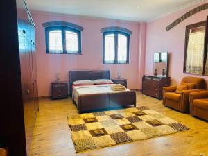 a bedroom with a bed and a couch and a chair at Busulla Guest House in Shijak
