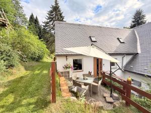a white house with a table and an umbrella at Naturhof Kluge in Saupsdorf