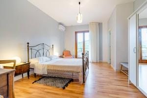 a white bedroom with a bed and a chair at B&B Sophia in Santa Sofia dʼEpiro