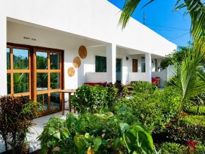 a white house with plants in front of it at Kendwa Crystal Coast Hotel in Kendwa
