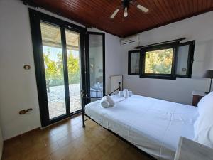 a bedroom with a large white bed and large windows at Nikiana Panorama in Nikiana