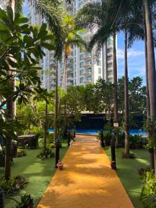 a pathway with palm trees and a large building at Nam Talay Condo Monthly only in Na Jomtien