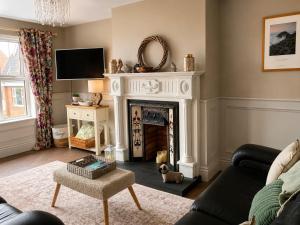 a living room with a fireplace and a tv at Grovehouse in Portstewart