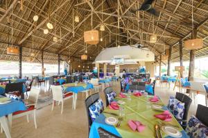 a dining room with blue tables and chairs at Canary Kendwa Beach Resort in Kendwa +225 photos