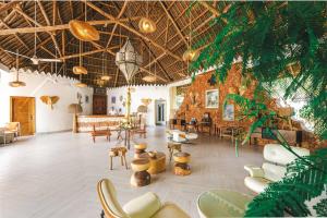 a large room with chairs and tables and ceilings at Canary Kendwa Beach Resort in Kendwa