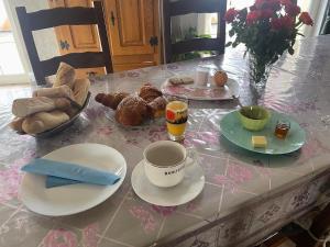 a table with plates and cups of coffee and pastries at chambre ZEN home Sérénité in Hazelbourg +16 photos