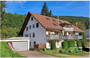 a large white house with a balcony at Ferienwohnung Hopfentraum in Alpirsbach
