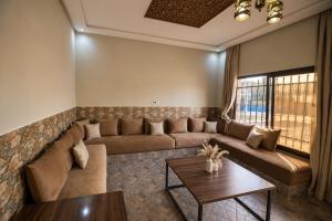 a living room with a couch and a table at Villa privée avec piscine chauffée in Oulad Teïma