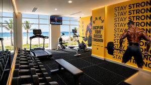 a gym with a large yellow wall with a man on it at Bosaso Airport Hotel in El Ad