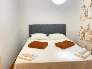 a bedroom with a bed with two towels on it at Apartment Joso in Primošten