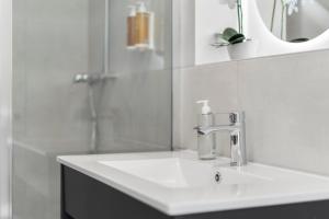 a white bathroom with a sink and a mirror at Tower Hotel Frankfurt in Frankfurt +94 photos