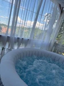 a hot tub in a room with a window at Vikendica Cokori - private pool and jacuzzi in Banja Luka +15 photos