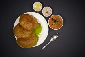 a plate of food with onion rings and sauce at Skyline Grand Hotel - Near IGI New Delhi Airport in New Delhi