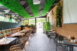 a restaurant with tables and chairs and green plants at Budget Hotel Rooms In Yerevan in Yerevan +38 photos