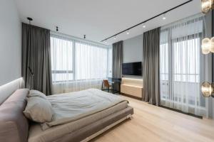 a bedroom with a bed and a television and windows at Skyline Grand Hotel - Near IGI New Delhi Airport in New Delhi
