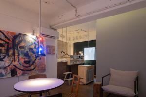 a living room with a table and chairs and a painting at apartment hotel Tasu Toco room 2 in Kichijōji